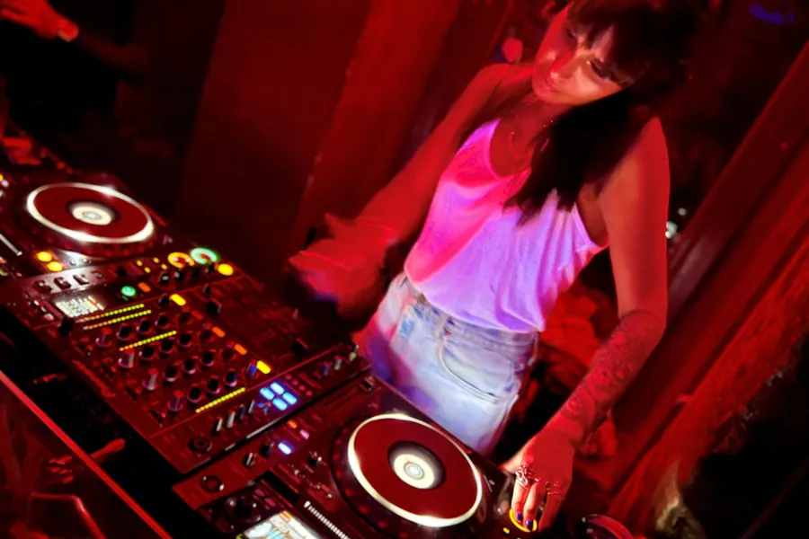Lily Rivers mixing on CDJs under red light
